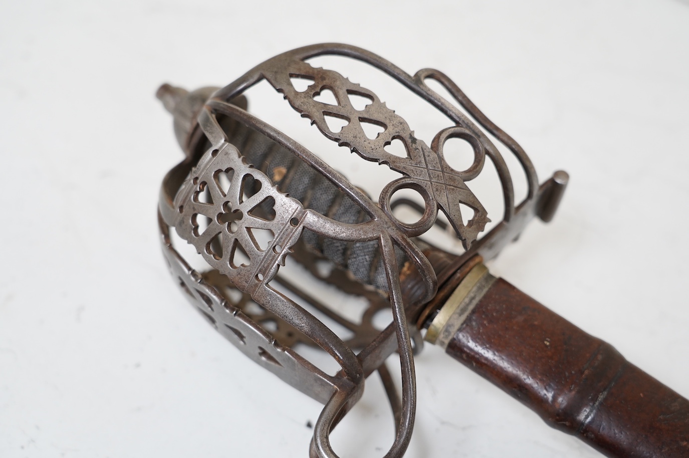 A late Victorian officer’s sword of the Black Watch, claymore blade etched with regimental title and VR cipher, regulation basket hilt, fish skin covered grip, in its leather covered field service scabbard, blade 82cm. C
